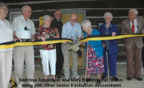 Ambrose Adamchick and Mary Borutski cut ribbon, 
along with other senior Kashubian descendants